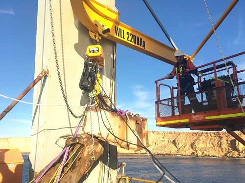 Rigger on an elevated work platform beside the shiploader portal frame, with the new monorail beam marked WLL 2200Kg overhead